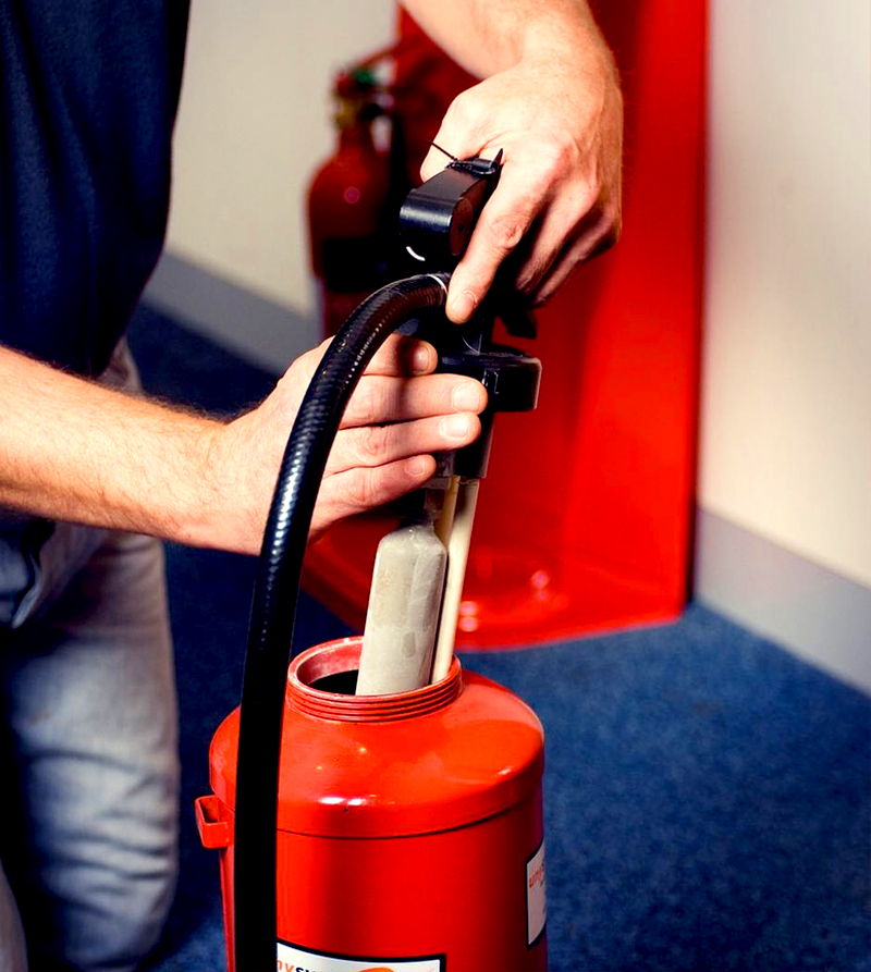 Técnico fazendo recarga de extintor de incêndio